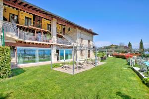 a house with a large yard with chairs on it at Agriturismo Cascina Crocelle - Lake View and Heated Pool in Padenghe sul Garda +88 photos