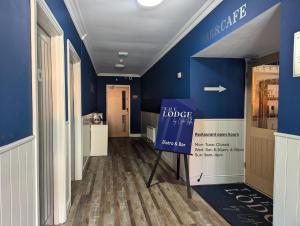 a hallway with blue walls and a sign that reads the lodge at The Lodge by Cefn Tilla in Usk