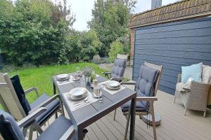 a table and chairs on a wooden deck with a table and chairs at Ferienwohnung Strandläufer Dagebüll in Dagebüll