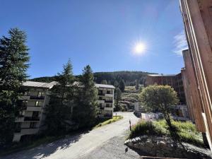 an empty street with buildings and the sun in the sky at Chalet Arlovi - CHALET PRESTIGE 8 P. PROCHE PISTES-Tout inclus MAE-9433 in Vars