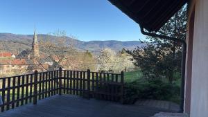 un porche avec une clôture et une vue sur une église dans l'établissement Romantic Hideaway & Remote Work Haven pet friendly, à Neuve-Église