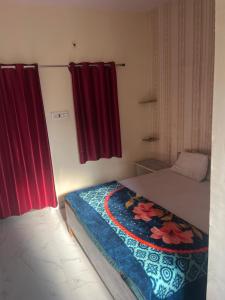 a bedroom with a bed and a red curtain at Hotel Shree Bhati Brothers in Jodhpur