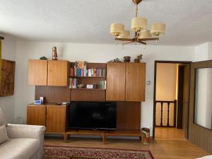 a living room with a flat screen tv and wooden cabinets at Chesa Crasta 6 in Samedan