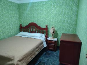 a bedroom with a bed and a table with a lamp at Tu Jardín Secreto Cachi in Cachí +4 photos