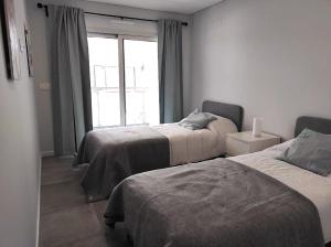 Monte GordoにあるEanes 22 Beach Houseのベッド2台と窓のある寝室