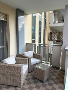 a balcony with wicker chairs and a table at House Trenno in Milan