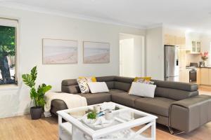 a living room with a couch and a table at The Garden Townhome - Heart Of Wollongong in Wollongong
