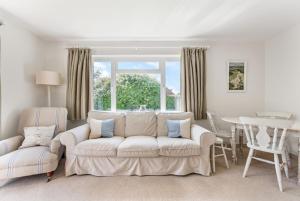 a living room with a white couch and a table at 21 Owers Way, West Wittering in West Wittering