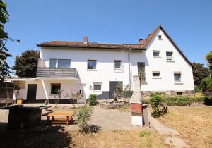 a white house with a picnic table in front of it at City Rooms Heppenheim in Heppenheim an der Bergstrasse