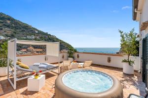 a hot tub on a balcony with a view of the ocean at Torre Paradiso in Minori