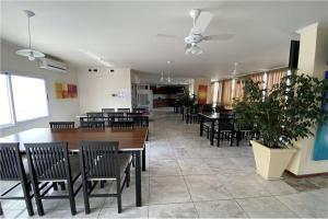 a dining room with tables and chairs and a plant at Departamento Céntrico Miralejos 3 in Villa Carlos Paz