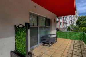 a balcony of a building with a bench on it at Jazzy Garden Apartment Komárno in Komárno +2 photos