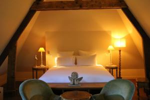 Un dormitorio con una cama y dos sillas. en Auberge Bout de Bois, en Saint-Jouin-Bruneval