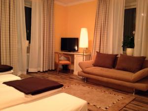a living room filled with furniture and a tv at Hotel Schlee in Hohenschäftlarn