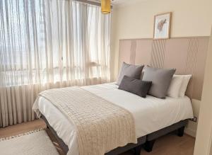 une chambre avec un grand lit avec une fenêtre dans l'établissement Altos de Las Condes, à Santiago