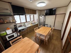 a small kitchen with a wooden table and chairs at E KI house ski school in Yuzawa