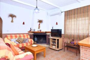 ein Wohnzimmer mit Sofa und Fernseher in der Unterkunft Cortijo Algarrobo - Casa de Campo tranquila- in El Llano de Don Antonio