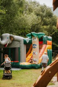 a child in a stroller in front of a playground at Pri Piecke penzión a reštaurácia in Staré Hory