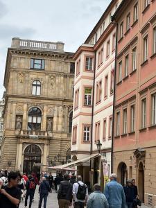 een groep mensen die op straat voor een gebouw lopen bij Apartmán LACRON Praha in Praag