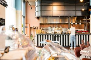 un hombre de pie en una cocina preparando comida en The Social Hub Delft, en Delft