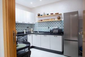 a small kitchen with a refrigerator and a dishwasher at Majorelle Elegance City Center - Parking - Balcon in Marrakesh