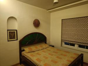 ChinchwadにあるSpacious 2BHK with ensuite bath and officeのベッドと窓のある寝室 +8枚の写真