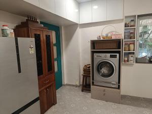 ChinchwadにあるSpacious 2BHK with ensuite bath and officeのキッチン(洗濯機、冷蔵庫付)