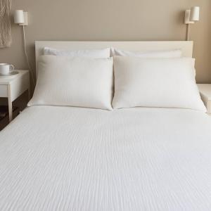 ein Bett mit weißen Laken und Kissen darauf in der Unterkunft Private Cozy Room in Downtown Toronto, Steps to Subway & CN Tower in Toronto