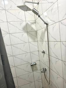una ducha con puerta de cristal en un baño en The Willows Apartment - Cozy Two Bedroom all en-suite Apartment, en Kumasi 6 fotos más