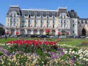 a large building with flowers in front of it at Les Cavaliers in Cabourg