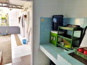 a kitchen with blue tiles on the wall at Pondok Aulia by Slamet in Padayungan