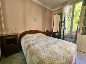 a bedroom with a large bed and a window at Le Jardin Edgar Malakoff in Malakoff