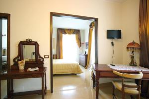 a bedroom with a bed and a desk and a mirror at Hotel Roma in Scanno