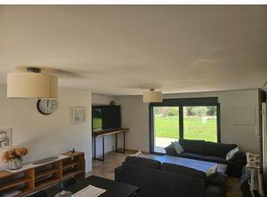 un salon avec un canapé et une télévision dans l'établissement Les oliviers, à Saint-Didier