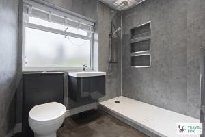 a bathroom with a toilet and a shower and a window at Rosie's Central House With Drive Parking in Nottingham +44 photos