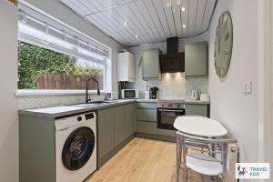 a kitchen with a washing machine and a washer at Rosie's Central House With Drive Parking in Nottingham