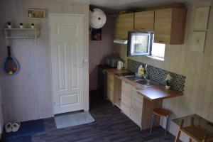 a small kitchen with a door and a sink at Välja Puhkemaja in Üksnurme