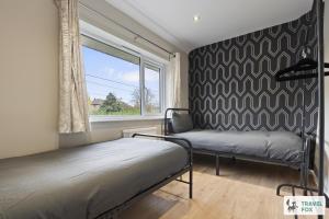a bedroom with two beds and a window at Rosie's Central House With Drive Parking in Nottingham