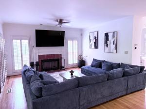 sala de estar con sofá grande y chimenea en Star Mansion Atlanta, en Atlanta