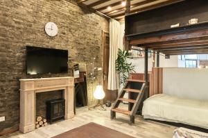 a bedroom with a fireplace and a tv on a brick wall at duplex 1 bedroom apartment on Wuyuan Road close Changshu Road station in Shanghai