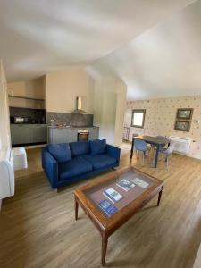 a living room with a blue couch and a table at VILLA VALLE FRANCIACORTA - Appartamenti per vacanze in Rodengo Saiano