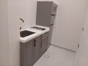 a small kitchen with a sink and a microwave at W Hotel Apartment in Taif