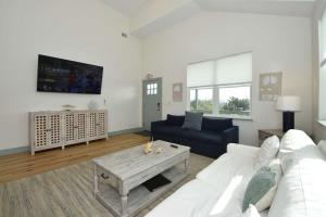 a living room with a white couch and a table at Luxury Beach Home with Heated Pool in Marineland