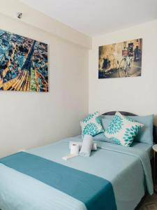 a bedroom with a bed with blue sheets and pillows at Norman Condominium Unit Rental in Dumaguete