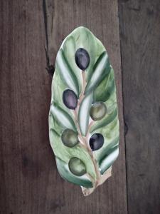 a green leaf with black olives on it at El Olivo in Gualeguaychú