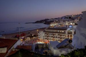 a view of a city with a beach at night at Micului Refugiu in Albufeira