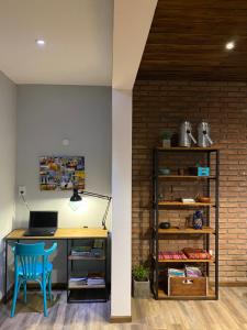 an office with a desk with a laptop and a blue chair at Casa Los Nogales in Roldán +21 photos