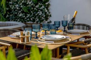 a wooden table with plates and blue glasses on it at Micului Refugiu in Albufeira +48 photos