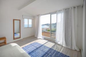 a bedroom with a large window with a view of the ocean at Micului Refugiu in Albufeira