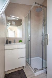 a bathroom with a shower and a sink and a mirror at Micului Refugiu in Albufeira